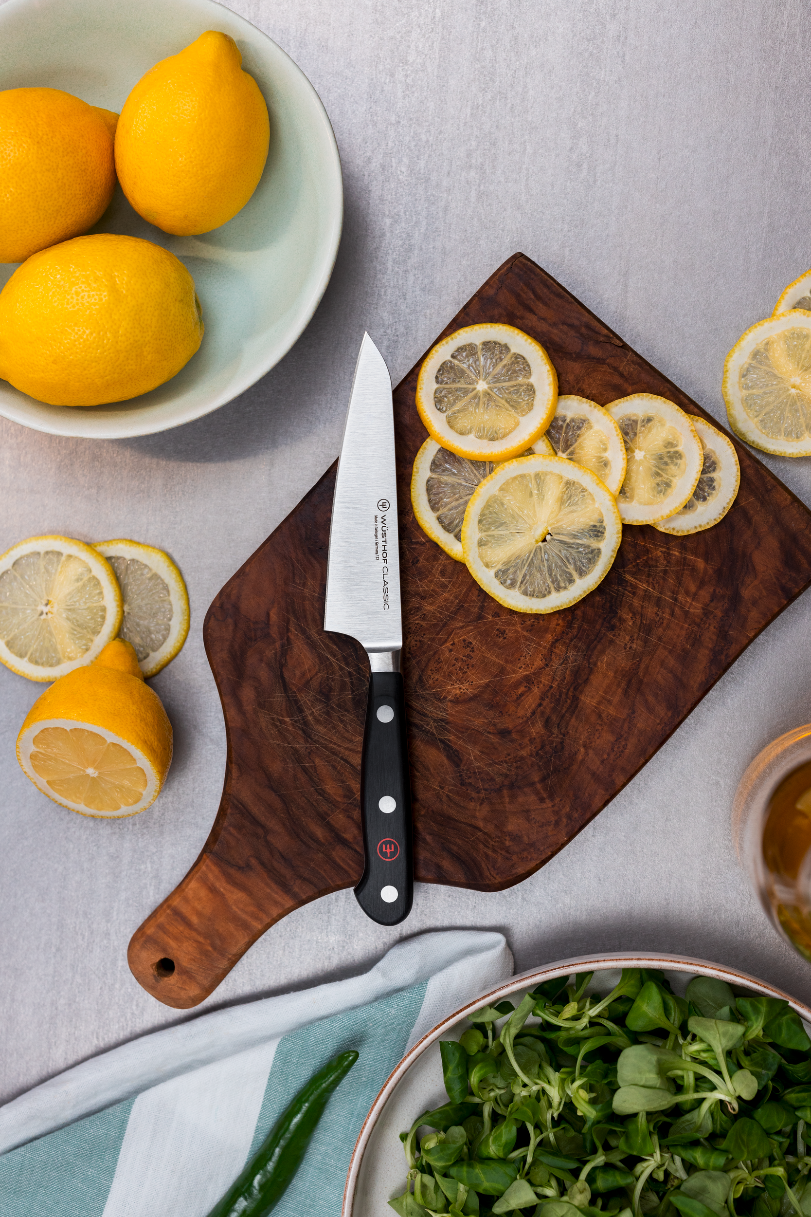 Wusthof knife on a cutting board with lemons.